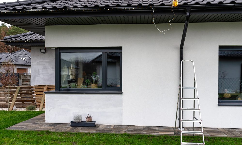 Expert gutter installation services in florida Installing LED lights along the gutter around the house, decorating the house for the holidays.