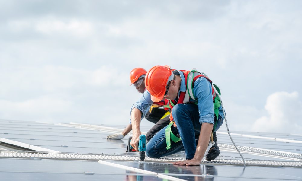 Expert Roof Inspection Company in Florida Technician inspection and repair solar cell on the roof of factory.